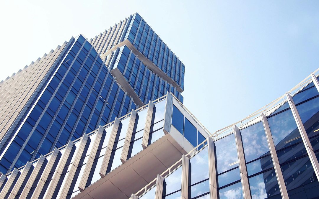 A modern architectural building with angular shapes and blue-tinted glass windows stands strikingly against the clear sky, reminiscent of the innovative designs found in Tampa.