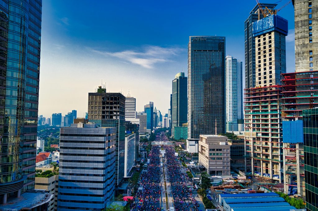Aerial view of a bustling city like Tampa, with high-rise buildings and busy streets filled with people and vehicles under a clear sky.