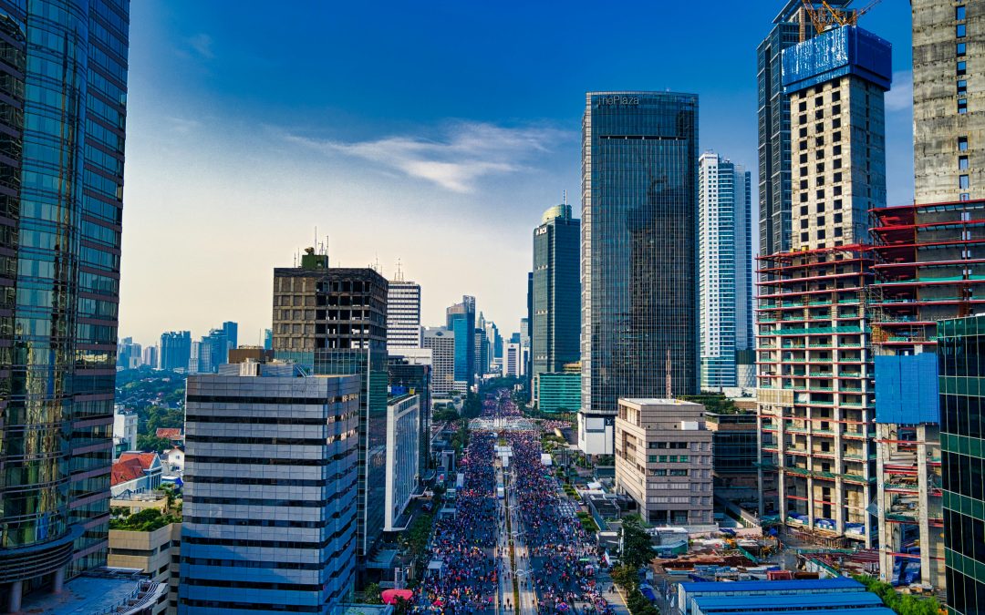 Aerial view of a bustling city like Tampa, with high-rise buildings and busy streets filled with people and vehicles under a clear sky.